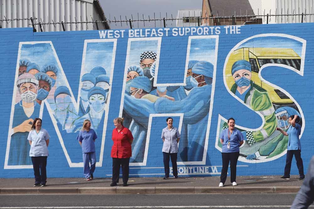 Noord-Ierse National Health Service-medewerkers (NHS) voor een muurschildering in Belfast die steun aan hen uitspreekt. – © Niall Carcon / PA Images / Getty