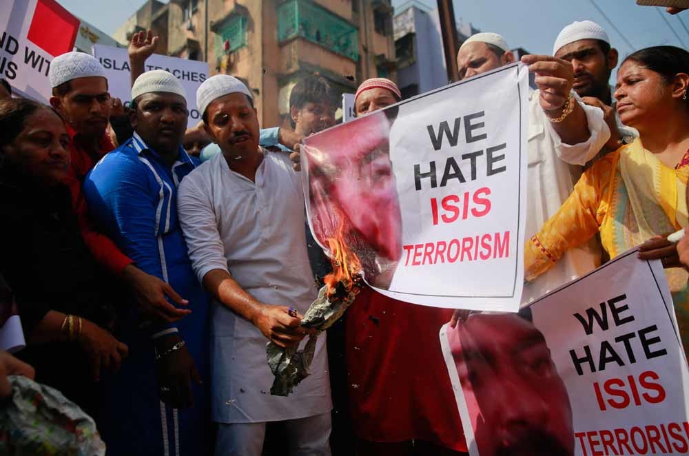 Indiase Moslims in Mumbai verbranden een poster van IS-leider Abu Bakr al-Baghdadi in reactie op de aanslagen in Parijs. – © Rafiq Maqboo / AP
