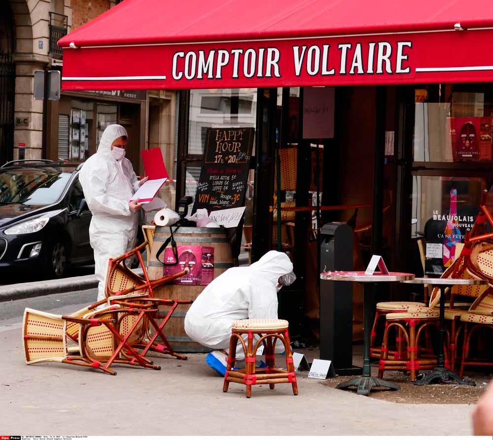 Leden van de Forensische Opsporing verzamelen bewijsmateriaal bij café Comptoir Voltaire. – © SIPA / HH