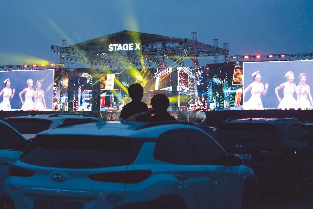 Publiek kijkt vanuit de auto naar een optreden tijdens het muziekfestival Stage X, op 25 mei. Meer dan duizend mensen waren aanwezig bij dit ‘social-distance-evenement’ op een parkeerplaats in een buitenwijk van Seoul. – Ahn Young-joo / AP