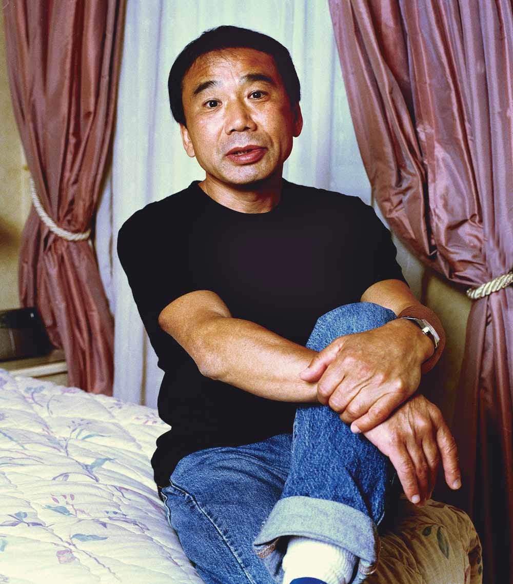 De Japanse auteur Haruki Murakami in 2003.  Het werk van Murakami is vertaald in meer dan vijftig talen en is wereldwijd miljoenen keren over de toonbank gegaan. – © Eamonn McCabe / Popperfoto / Getty