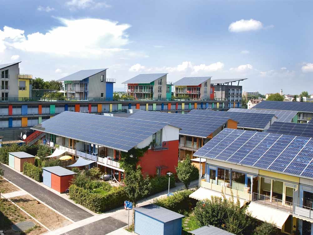 De door Rolf Disch ontworpen zonnewijk in Freiburg, met op de achtergrond het zonneschip waar zijn bureau kantoor houdt. De gebouwen wekken meer energie op dan ze verbruiken. – © Andrew Glaser / Wikipedia