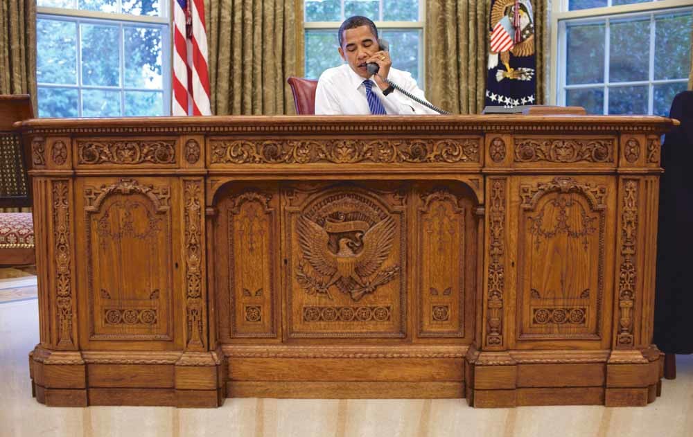 President Barack Obama voert in 2009 een telefoongesprek vanachter de Resolute Desk. – © Pete Souza
