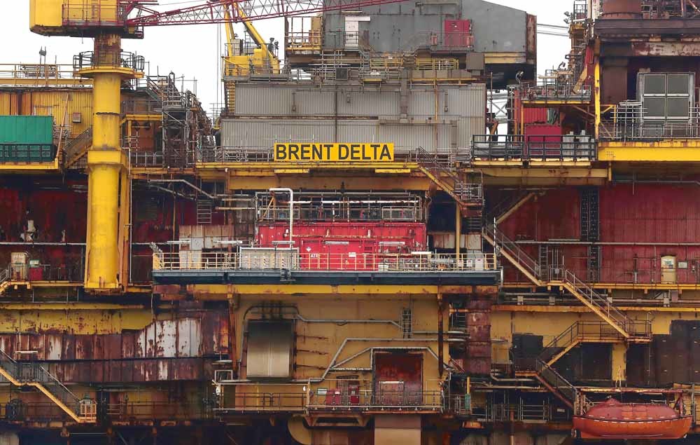 Een offshoreboorplatform van Shell wordt naar de haven gesleept om ontmanteld te worden. Shell investeert nog steeds miljoenen in de exploratie van nieuwe aardolievelden.  © Scott Heppell / AFP