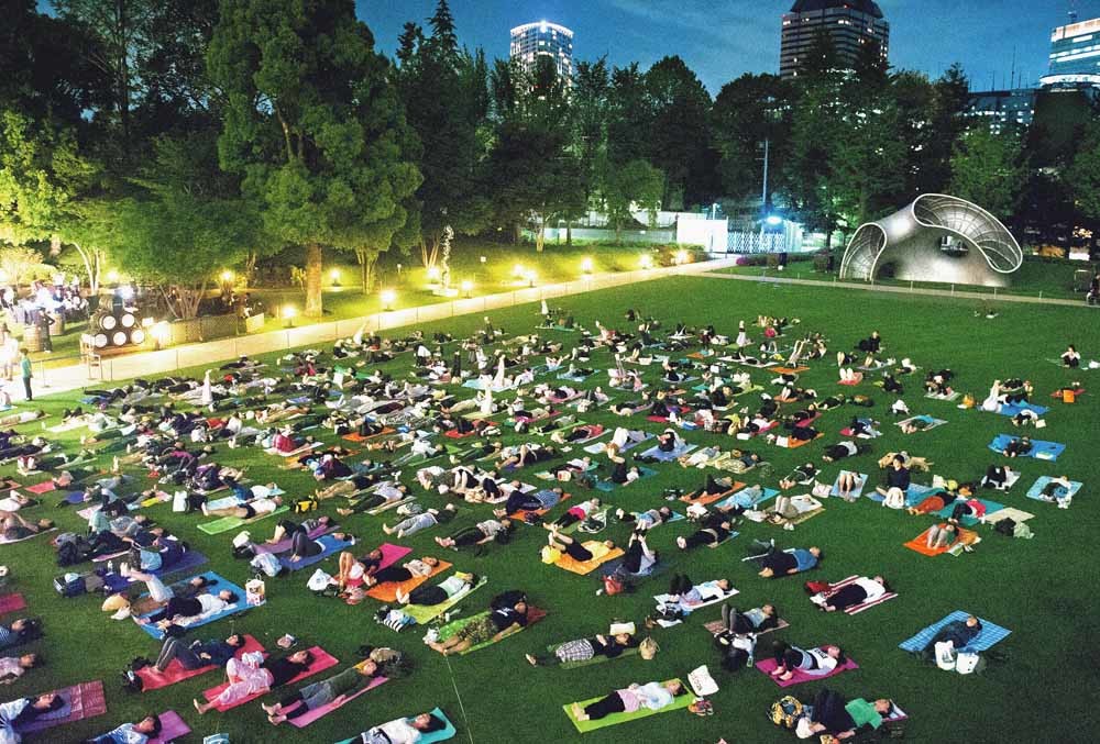 ‘Night Yoga’: In Tokio krijgen kantoorwerkers een yogales aangeboden. – © The Asahi Shimbun / Getty