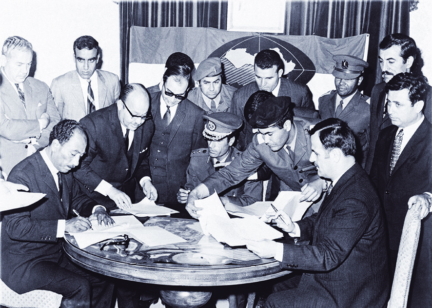  Anwar Sadat (links), Muammar Khadaffi (midden), en Hafez al-Assad (rechts), de leiders van respectievelijk Egypte, Libië, en Syrië, zetten hun handtekening onder de oprichting van een gezamenlijke federatie in 1971. - © Bettmann / Getty