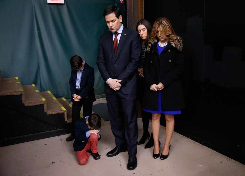 Republikeinse presidentskandidaat Marco Rubio bidt met zijn voltallige familie, aan de vooravond van de verkiezingen in, Iowa. – © AP / HH