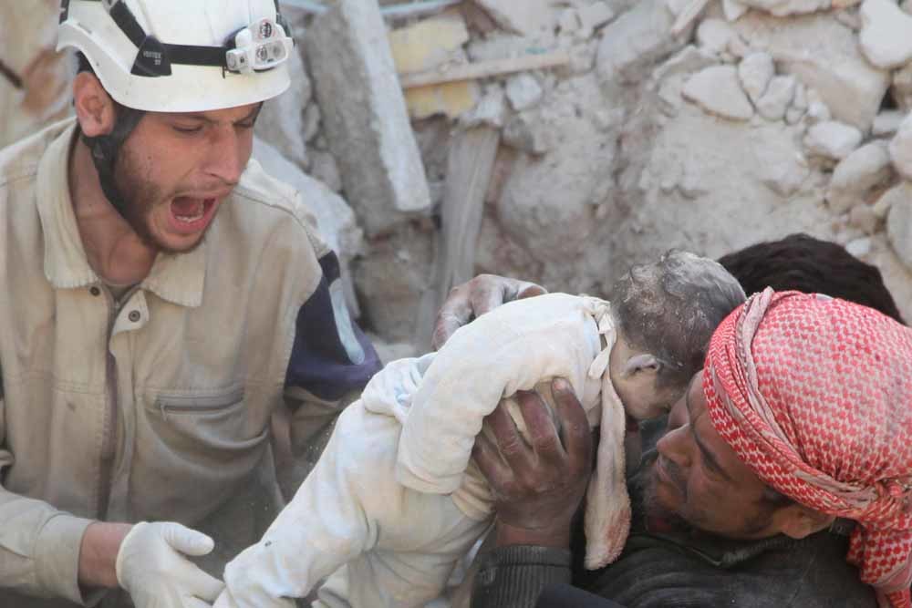Twee mannen met een dode baby, slachtoffer van de recente bombardementen op Aleppo. – © Reuters
