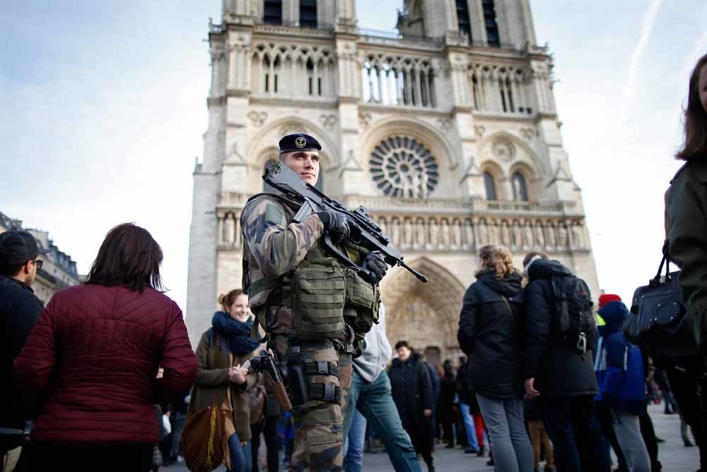 Een Franse soldaat patrouilleert voor de Notre Dame in Parijs. – © Charles Platia / Reuters 