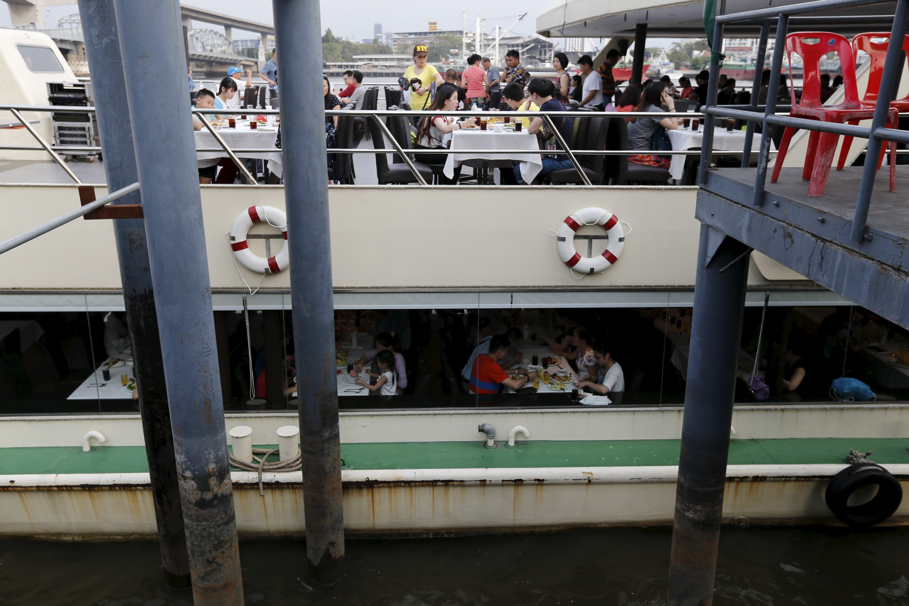 Chinese touristen dineren aan boord van een boot op de Chao Phraya-rivier in Bangkok. 16 februari 2016. – © Reuters / Jorge Silva