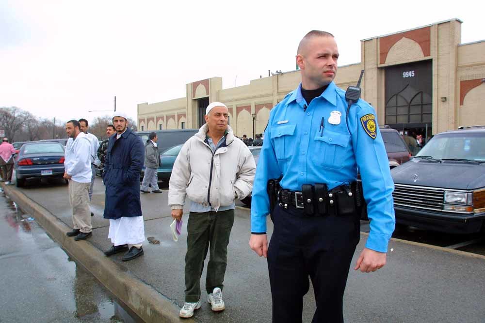 Een politieman in Dearborn houdt de wacht terwijl bezoekers de moskee verlaten, vlak na de aanslagen van 11 september 2001. – © Bill Pugliano / Getty Images