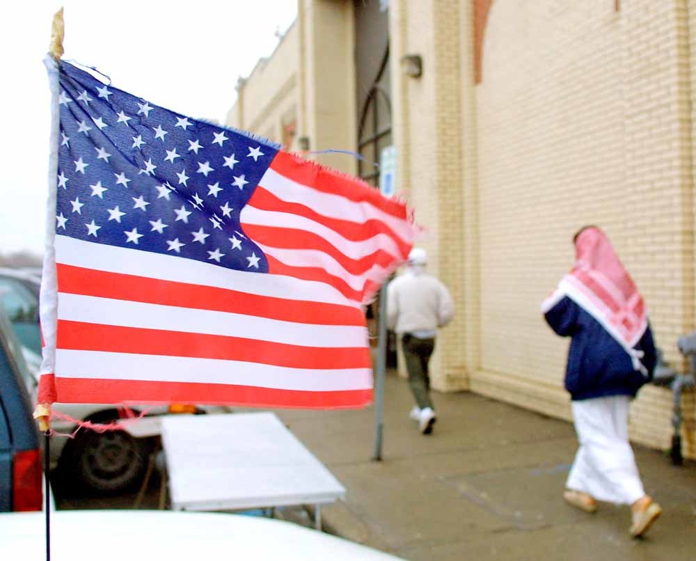 Moskeegangers passeren een auto met Amerikaanse vlag, eind 2001. –  © Bill Pugliano / Getty Images