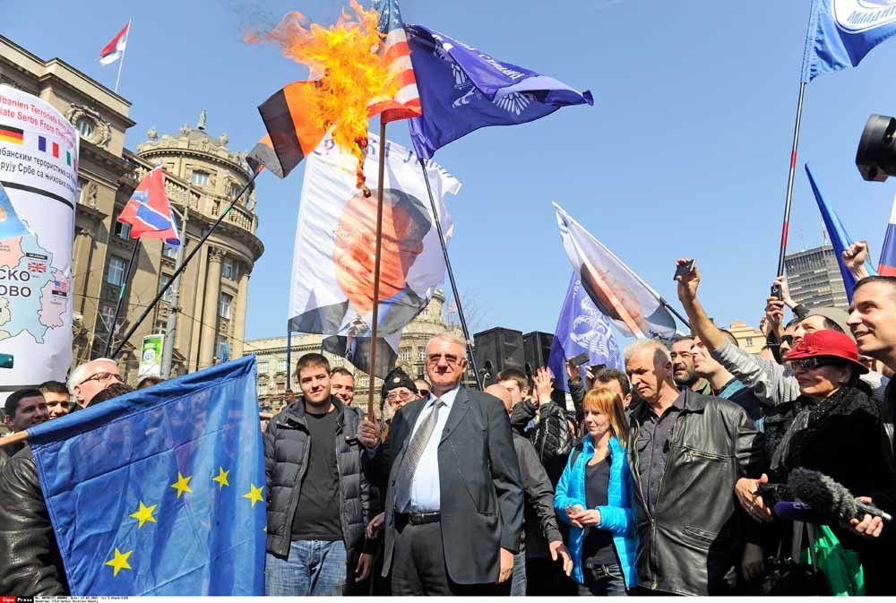Vojislav Seselj verbrandt een Amerikaanse vlag bij de herdenking van het NAVO-bombardement op Belgrado. –  © Hollandse Hoogte