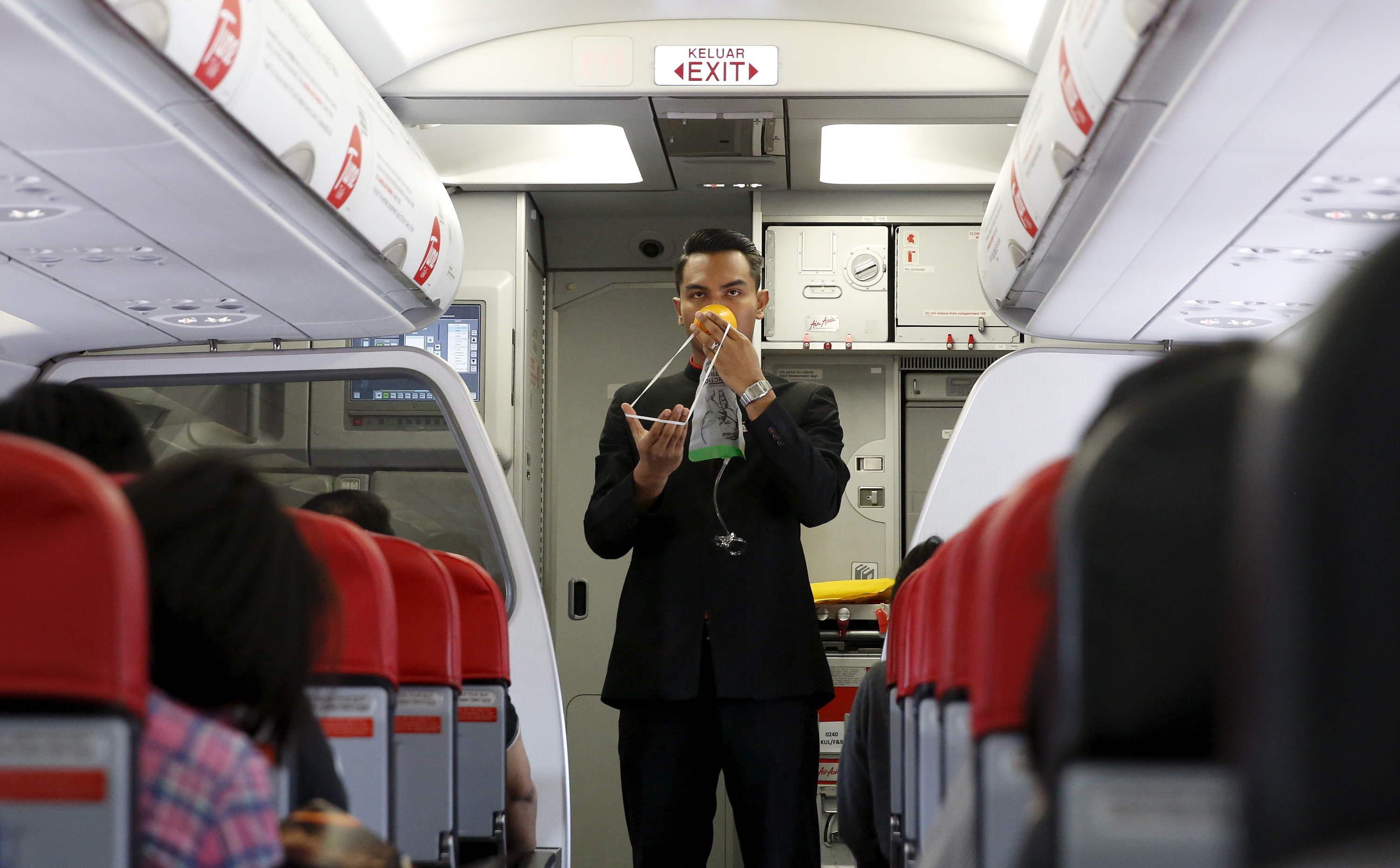 Een steward van AirAsia demonstreert de veiligheidsprocedures. © Olivia Harris / Reuters  