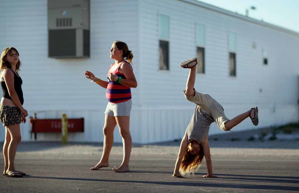 Drie meisjes spelen voor hun trailerwoning in Joplin, Missouri. – © Joe Raedle / Getty