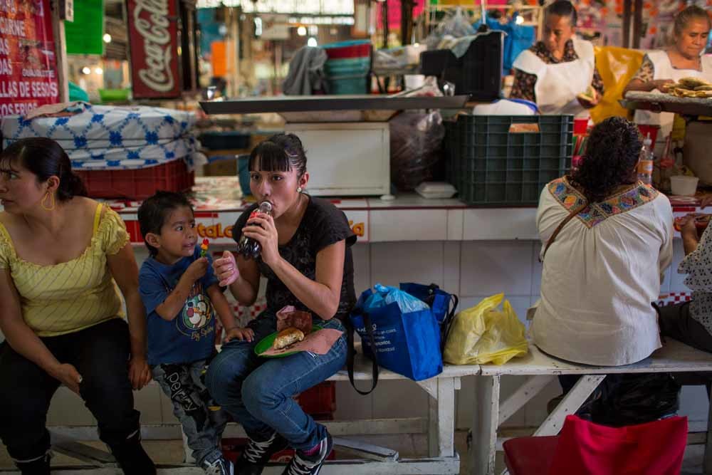 Jessica Diaz Torres (18) neemt een flesje cola bij de lunch. – © Adriana Zehbrauskas / Polaris