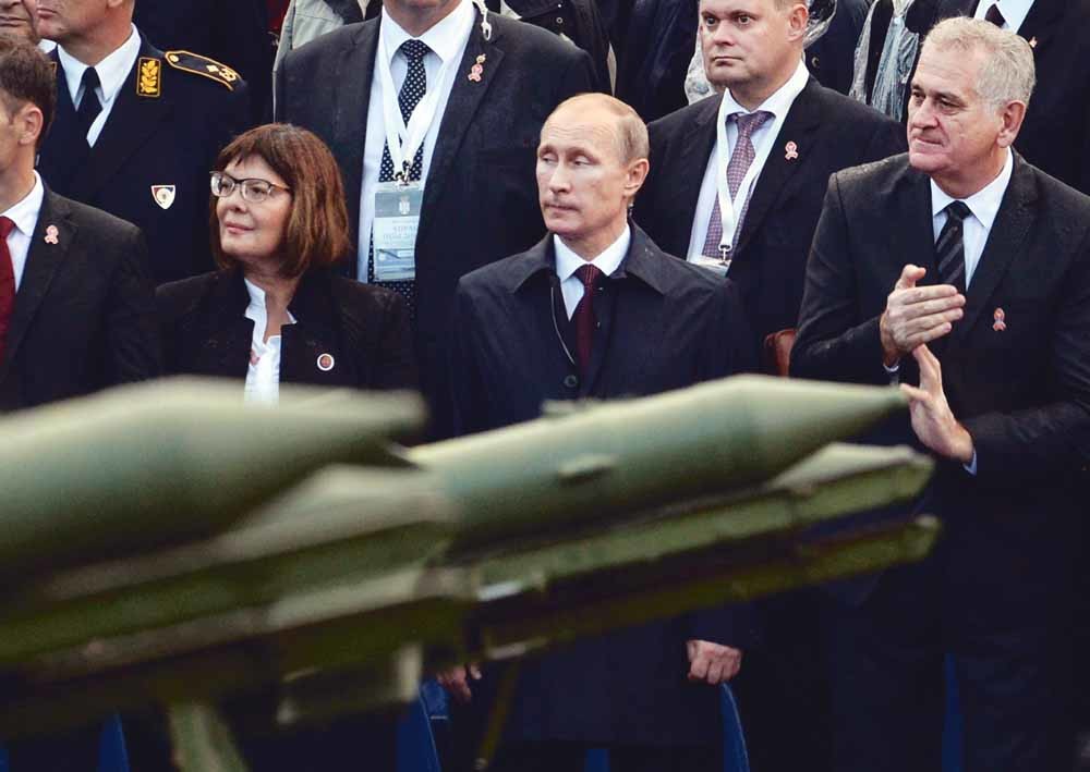 Vladimir Poetin en de Servische president Tomislav Nikolic tijdens een militaire parade in Belgrado. – © Vasily Maximov / Reuters
