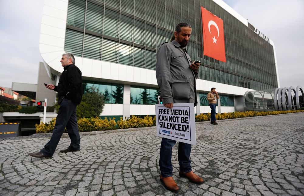 Een journalist van de Turkse Zaman Media Group protesteert bij het hoofdkantoor van het bedrijf in Istanbul. – © Murad Sezer / Reuters