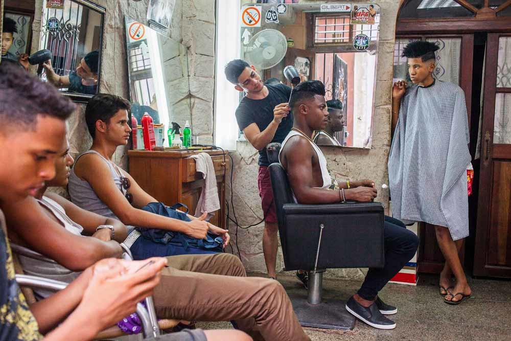 ‘Jongeren van nu’ in een kapperszaak in Havana. – © HH