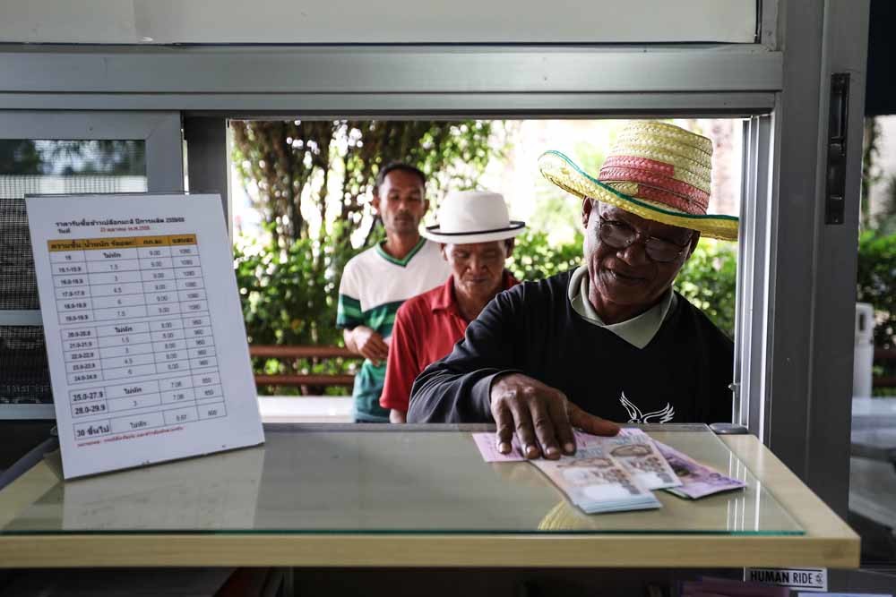 Rijstboeren worden uitbetaald door een rijstpeller in de Samrong-regio in het noordoosten van Thailand. – © Getty Images